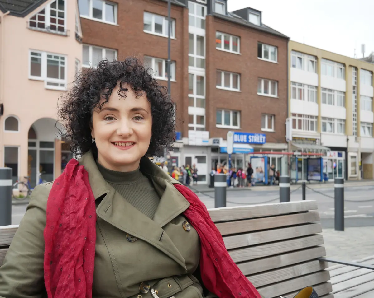 Katerina Passameras auf einer Bank vor dem Praxisgebäude in Troisdorf